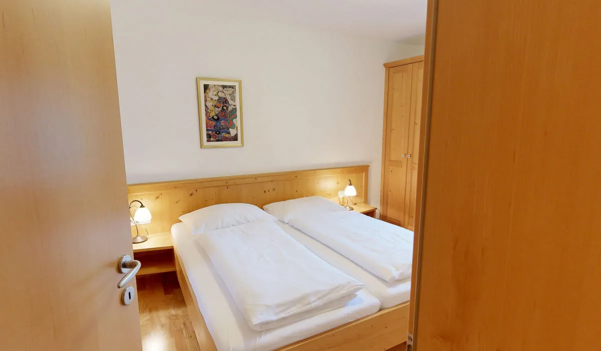 Einblick in ein Schlafzimmer mit zwei Betten und einem Gemälde an der Wand.