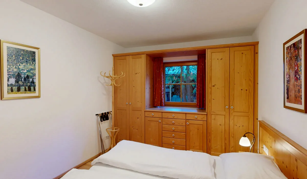 Zimmer mit Holzschränken, Fenster und Kunstwerken an der Wand